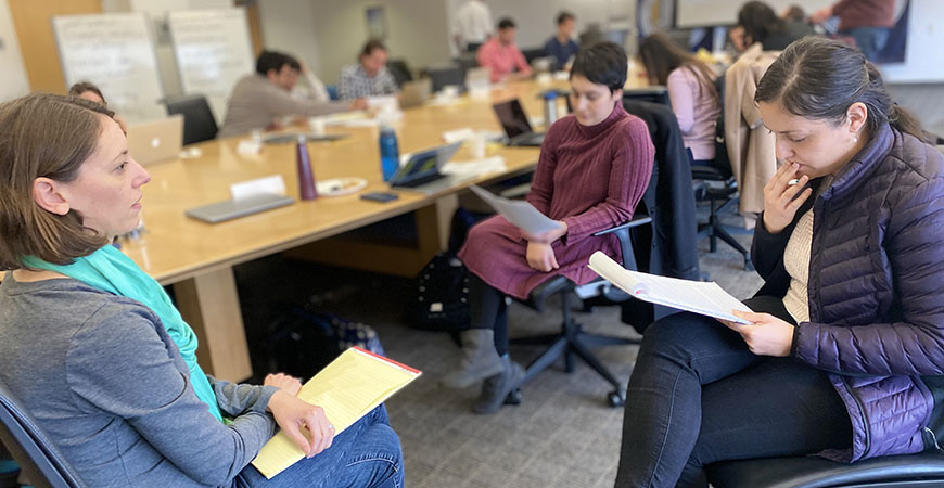 Fellows break off into small groups to discuss ways they can explain their research in clear and concise terms.